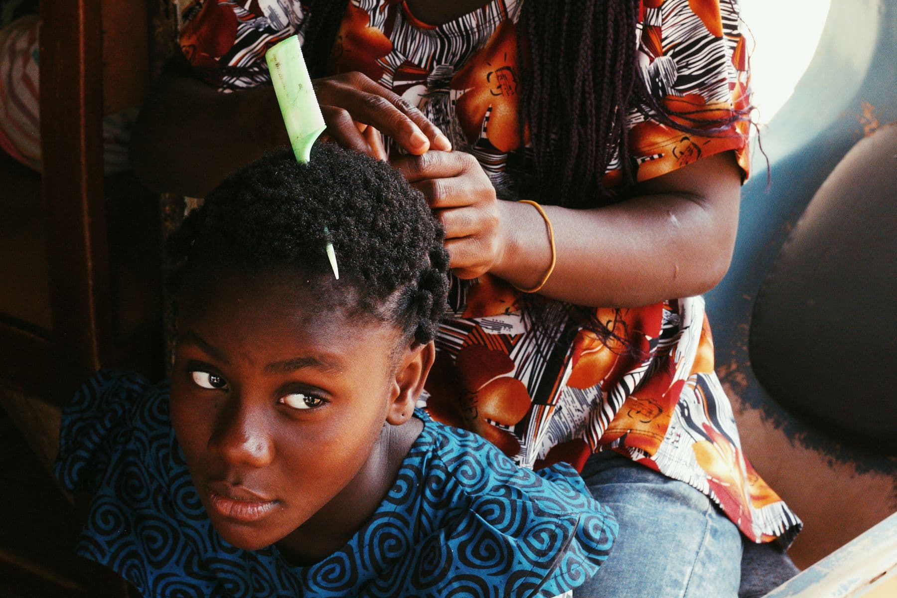 A hairdresser braiding a client's hair